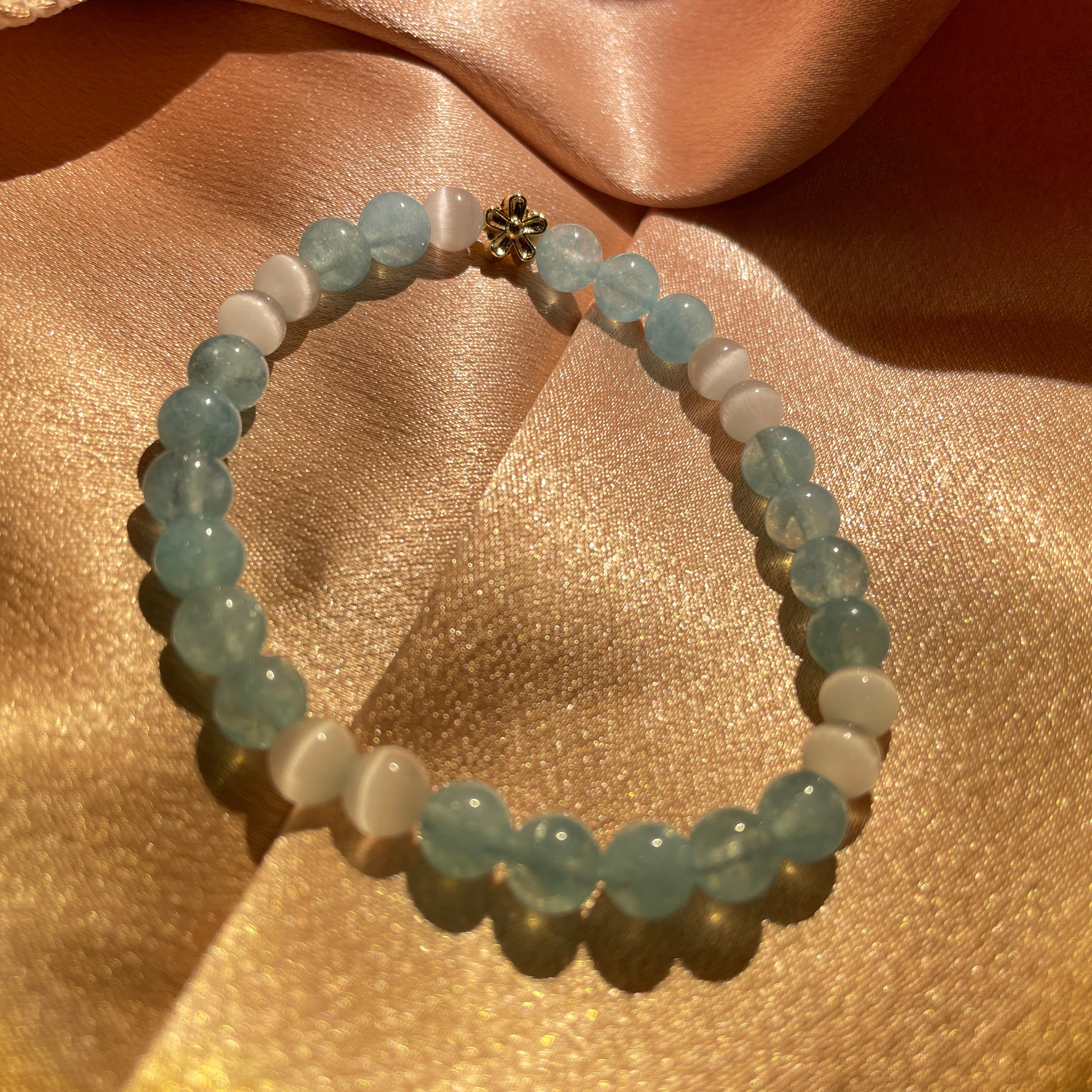 The picture shows a crystal bracelet called "Ocean Breeze", made of aquamarine and white agate. The bracelet is stunning, radiating the fresh and pure beauty of the ocean.