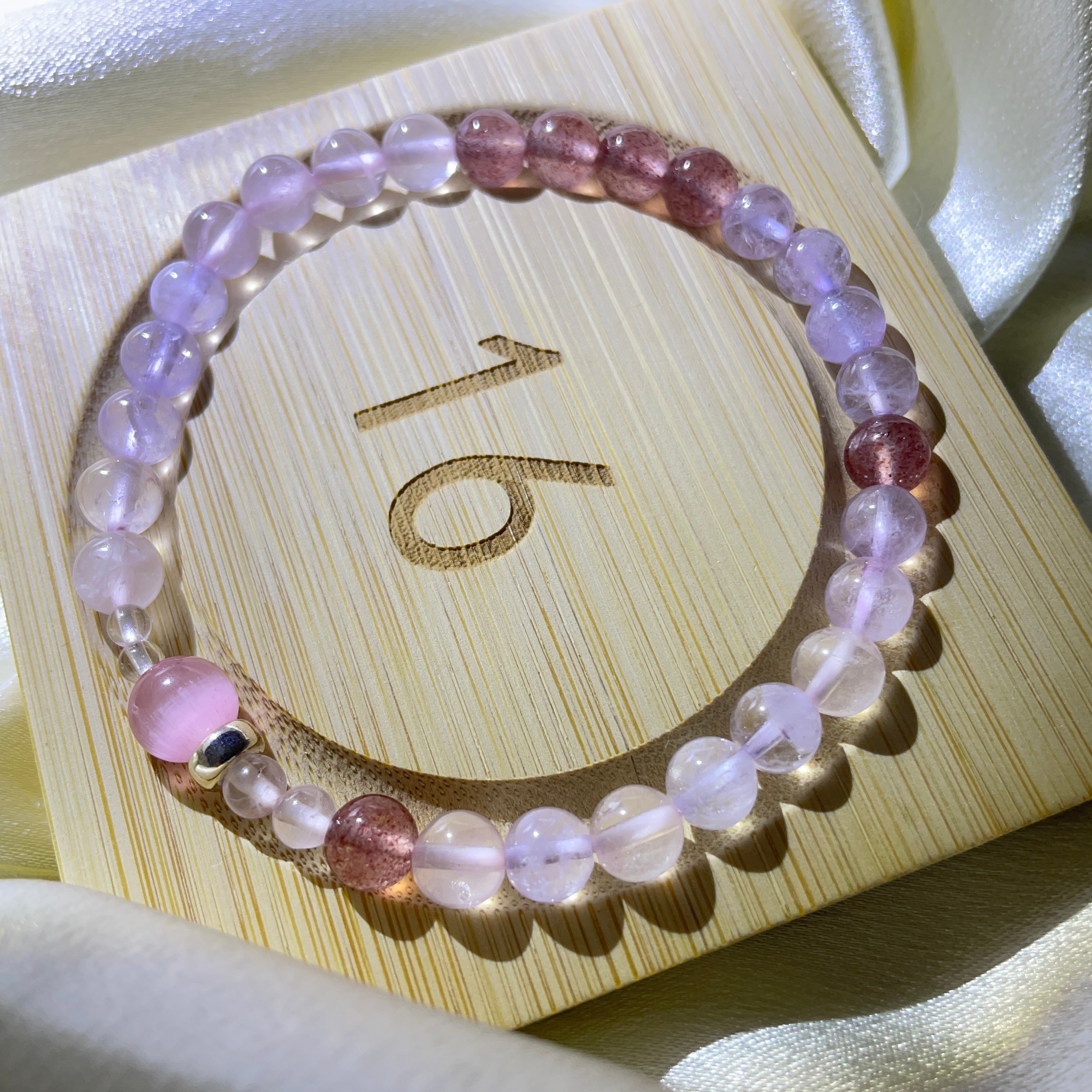 Image of a bracelet with purple, pink, and white crystals