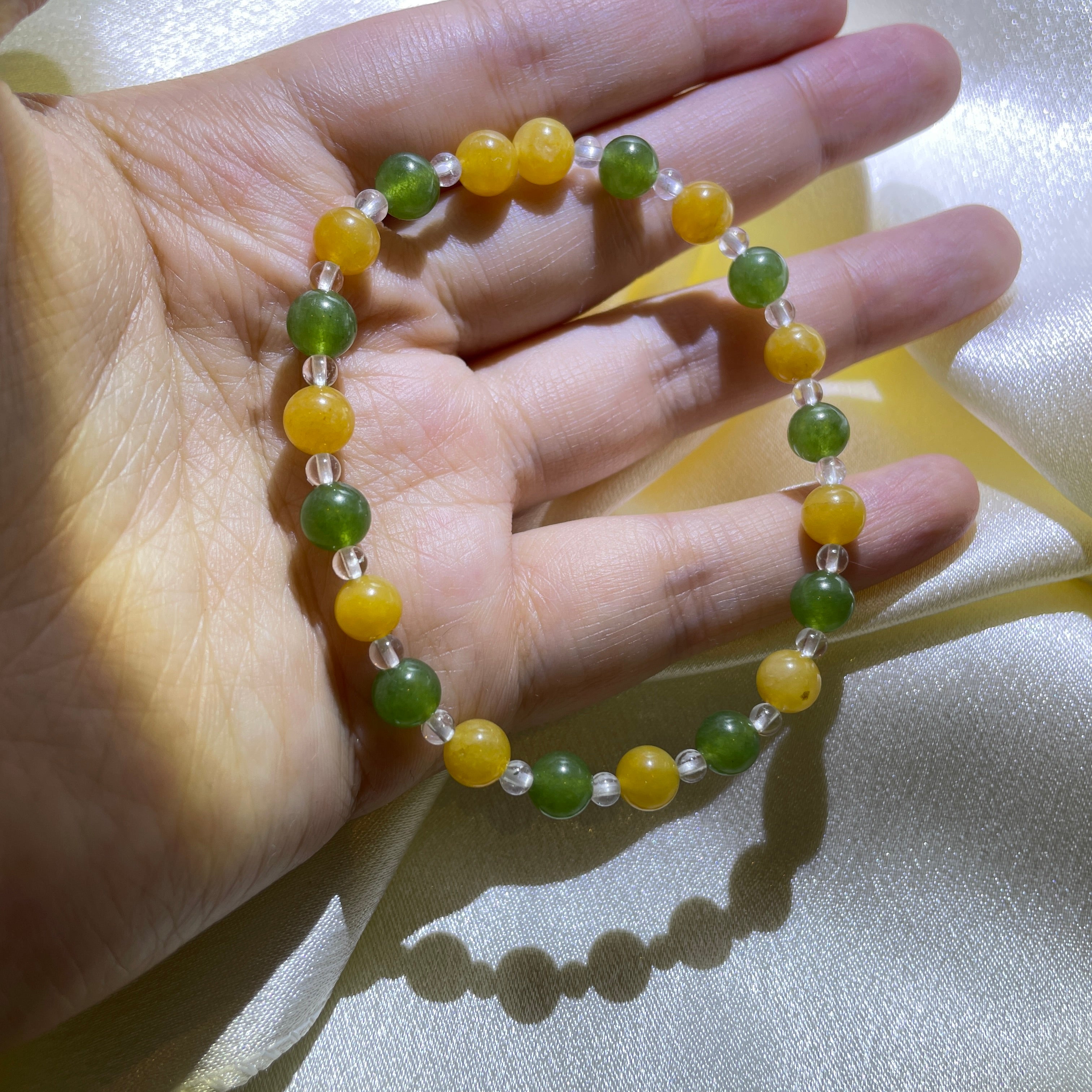 Image of a bracelet with green and white crystals