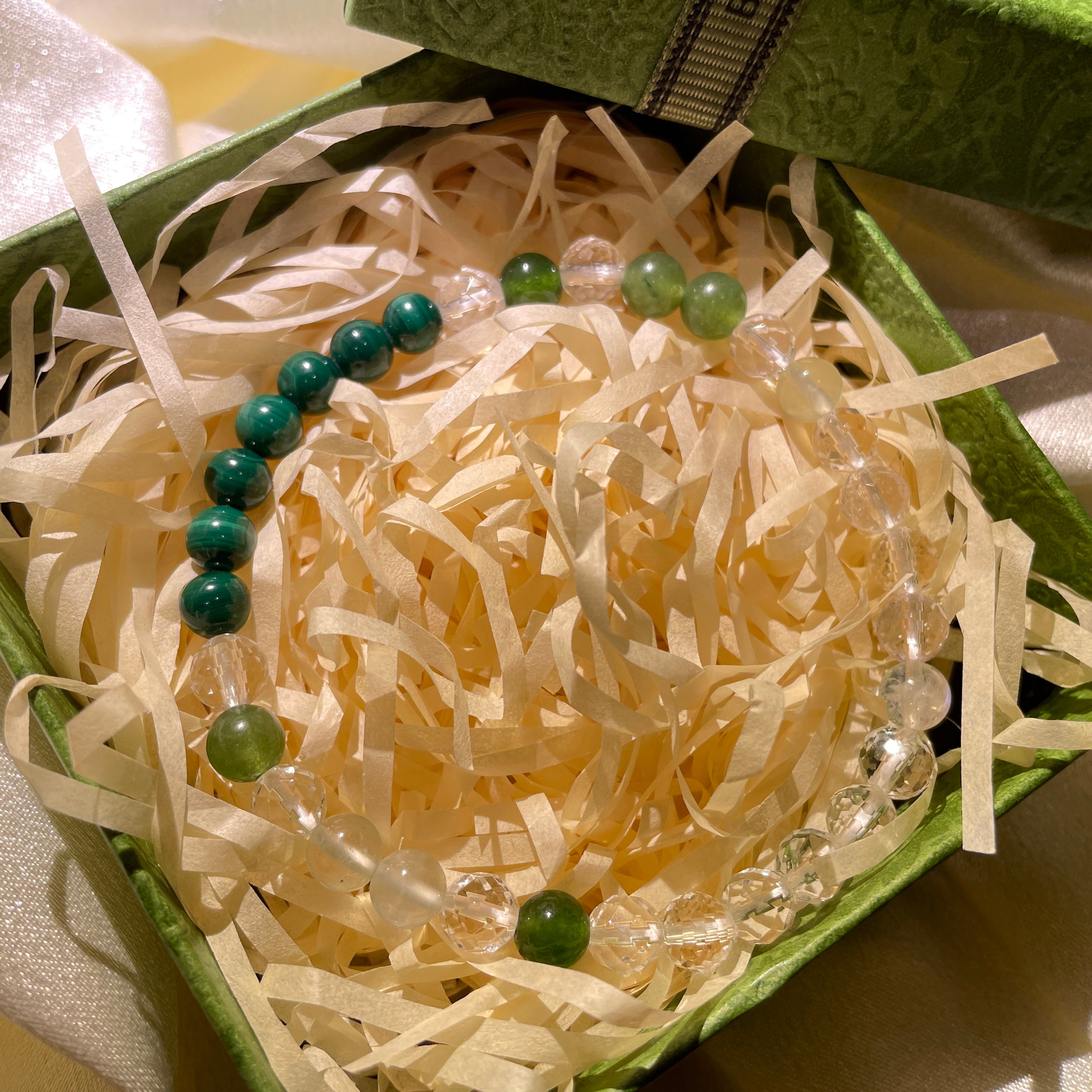 Image of a bracelet with green and blue crystals